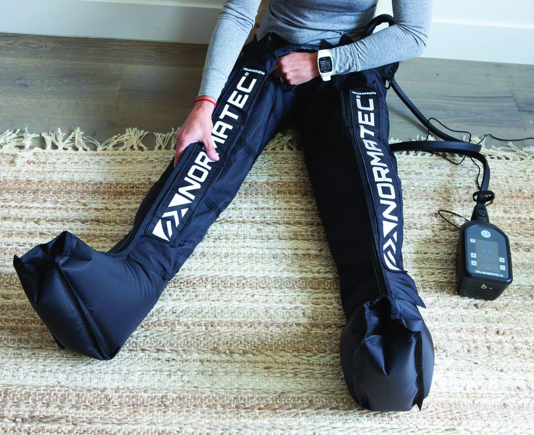 Hyperice NormaTec compression therapy boots being worn while seated